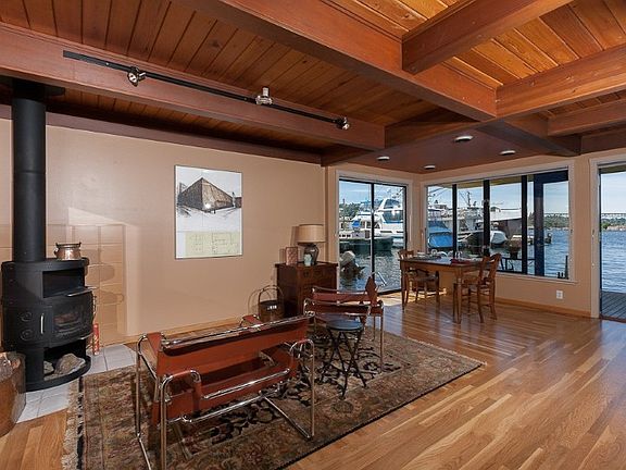 Living room w/wood stove is the center of a versatile open floor plan. Beautiful box-beam ceilings & lustrous, refinished wood floors.