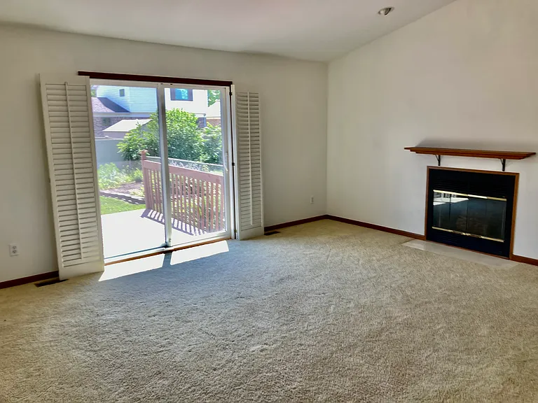 Vaulted Living room w/cozy fireplace and slider overlooking private backyard