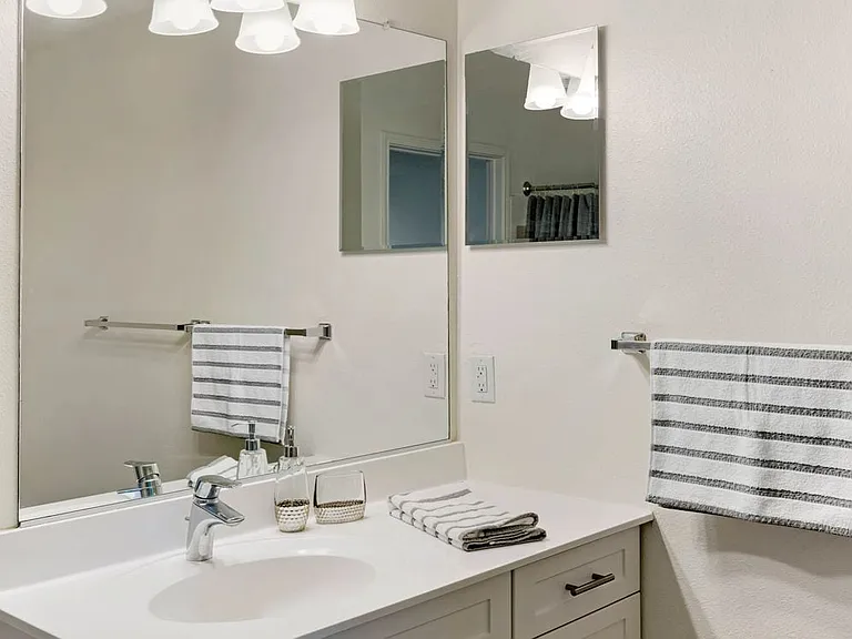 Classic Package bath with white cabinetry and hard surface flooring