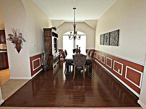 DINE IN STYLE IN THE FORMAL DINING ROOM FEATURING HARDWOOD FLOOR, PICTURE FRAME CHAIR RAILING, AND ARCHWAYS