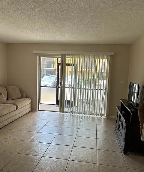 view of living room and screen in patio, can enter and exit from patio as slider has lock/key