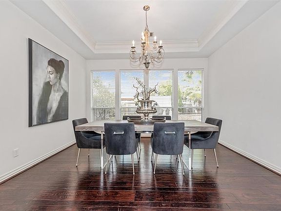 Tray ceilings unveil this marvelous formal dining room with impressive backyard views.