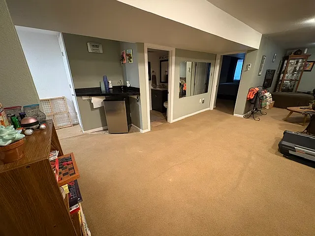 basement family room/rec room corner bar with fridge