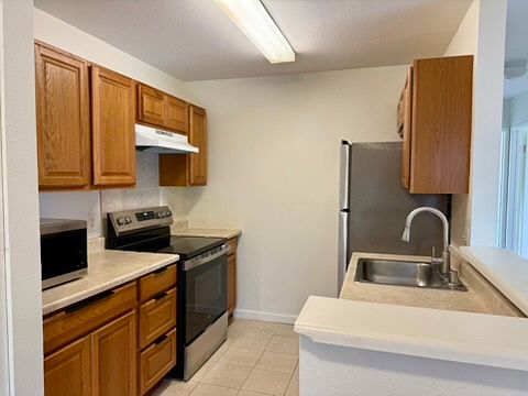 Kitchen equip with a refrigerator, stove/oven, dishwasher, and microwave