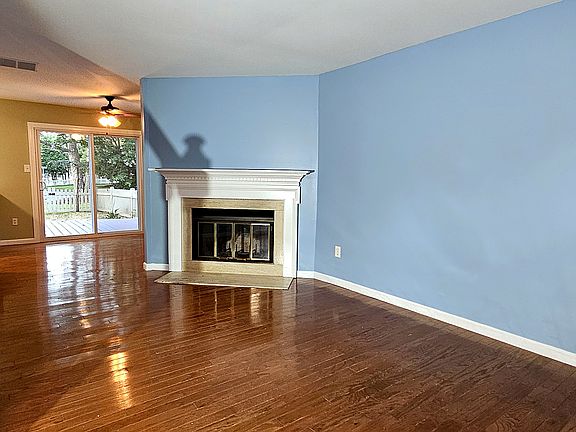 Wood-Burning Fireplace | 

The heart of the home: a real wood-burning fireplace with a classic white mantel, framed by gleaming hardwood floors and an open sightline straight through to the rear deck. |