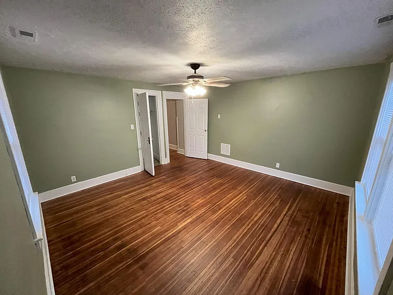 Large front bedroom with two sets of windows, overlooking street and sideyard.