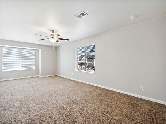 Expansive master bedroom with a box seat creates an inviting space.