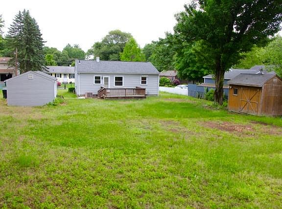 Large back yard with a deck and storage shed