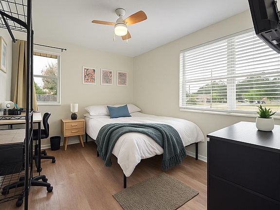 Modern full room with workspace, ceiling fan & bright windows comfortable home in Jacksonville