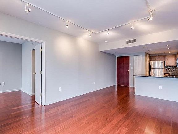 Living room w/view to second bedroom, kitchen, and front door