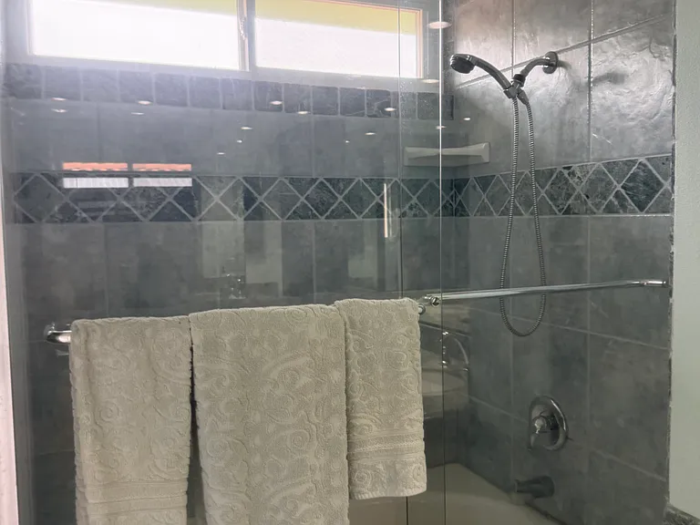 Primary tub features stone trim, tile and trim are repeated in private toilet room.