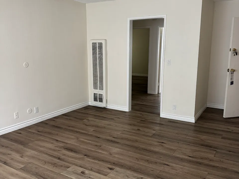 Living room showing the entrance to the small hallway where entrance to 2 bedrooms and bathroom.