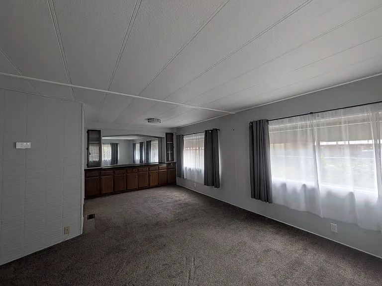 Living room facing dining area and sideboard cabinets.