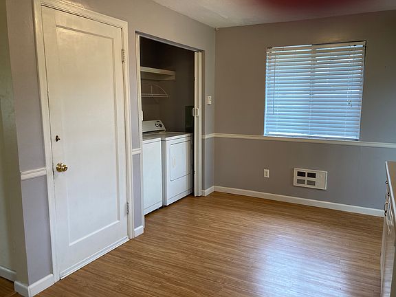 Laundry closet with full size machines next to storage garage entrance.