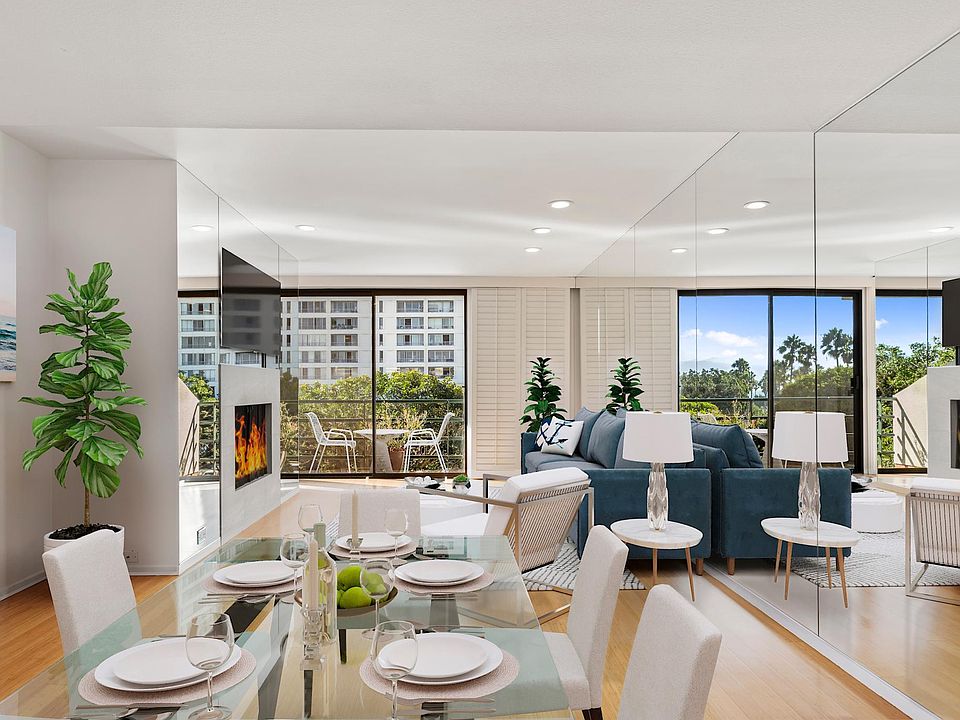 Living room with wood burning fireplace, hardwood floors, opens to balcony with some ocean views, central heating and a/c