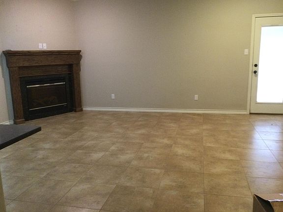 Large living room with fireplace and side door leading to side walkway.