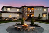 1 / 50Front of home with Elegant Tuscan façade Elegant Tuscan exterior with lit entry, fire feature, and circular drive