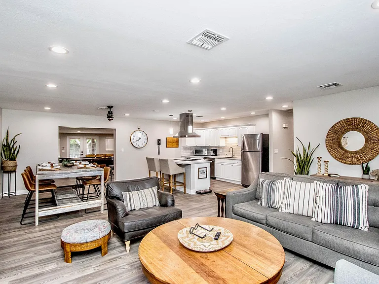 Bright, open-concept living area at Casa Del Sol, Tempe rental home. Showcases a seamless layout connecting the modern kitchen, rustic dining space, and cozy living room. Perfect for group gatherings and family vacations in Tempe, AZ.