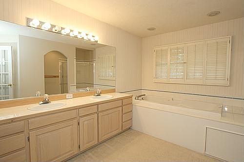 Master Bedroom Bath with dual tiled sinks, spa tub, shower and large walk-in
