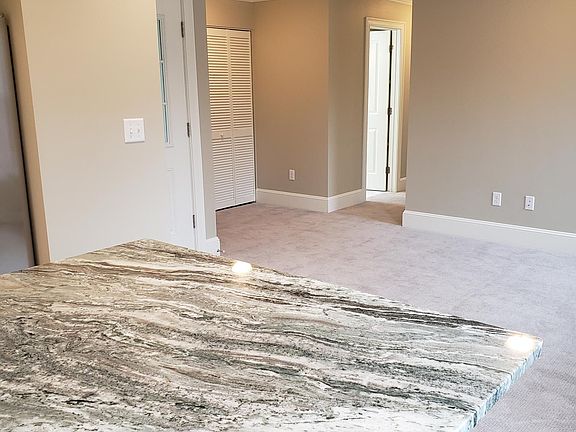 granite countertop island, ready for seating on two sides. looking into living area.