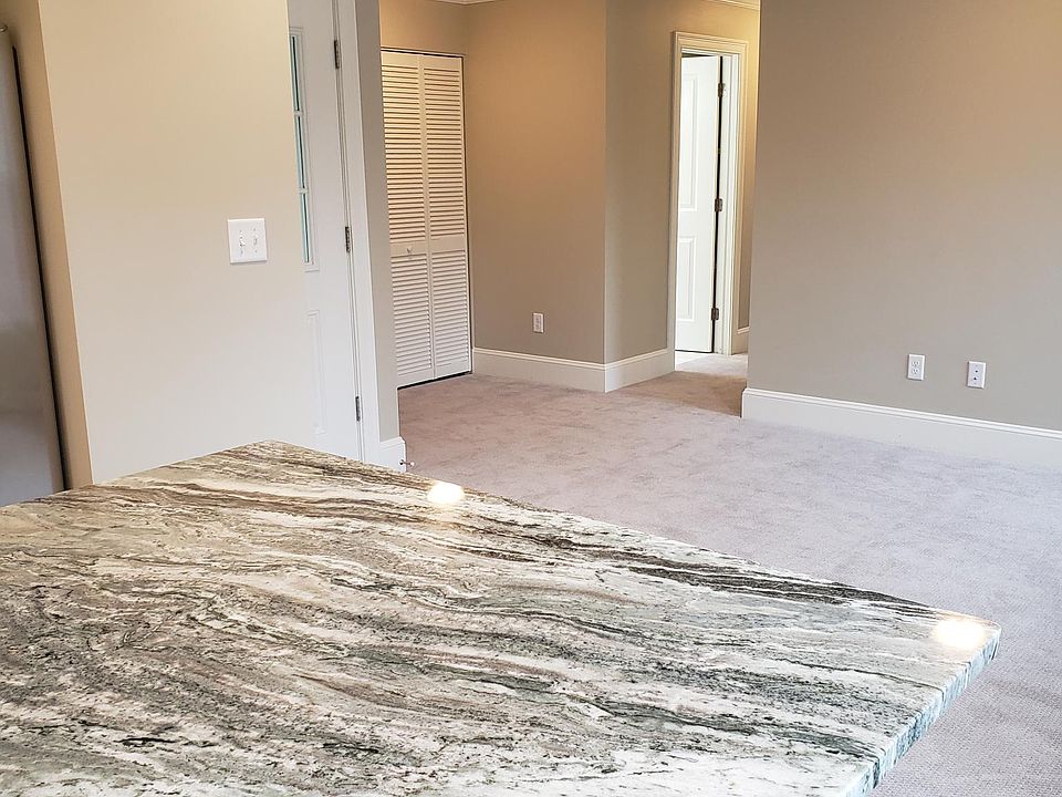 granite countertop island, ready for seating on two sides. looking into living area.