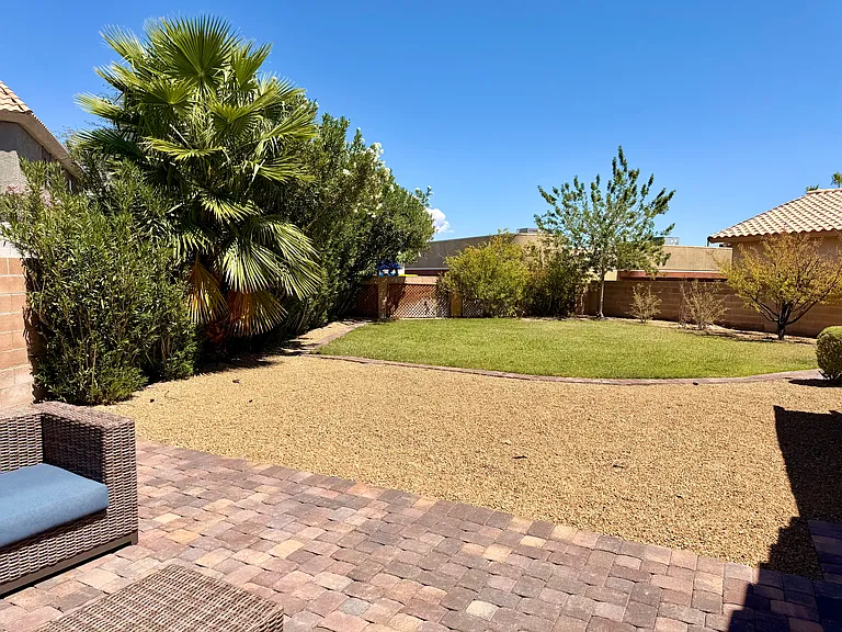 Gravel and grass area. 20 foot Oleander bushes provide privacy.