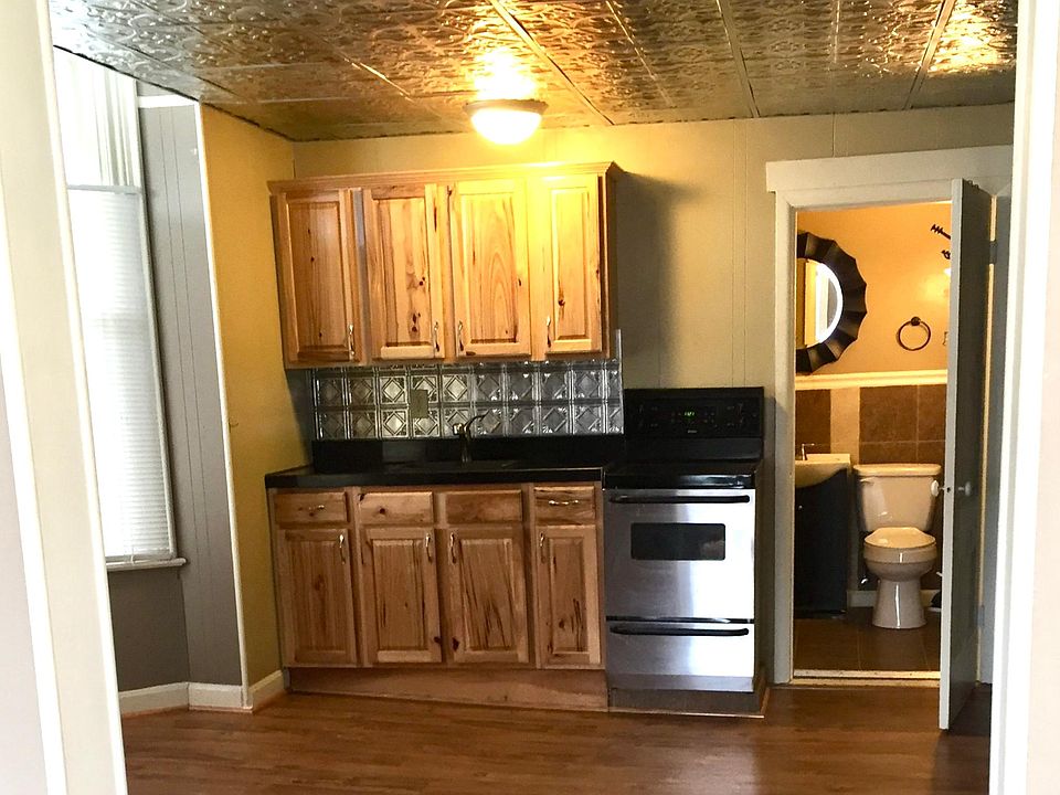 The kitchen has a granite countertop, a beautiful tin ceiling, a stainless steel stove and fridge, and updated flooring.