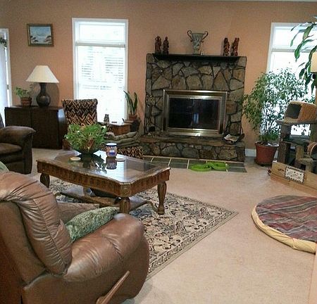 Living Room
						:
						Living room features stone wood-burning fireplace and view of pool area