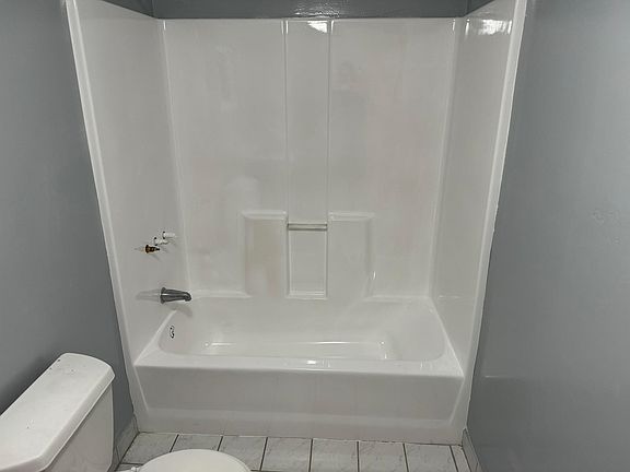 Bathroom 2 with new paint, refinished shower/tub, and new window.