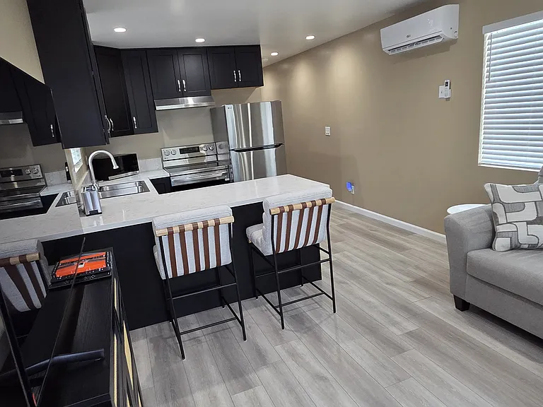 Living room with tv/stand sofa and end table. Barstools