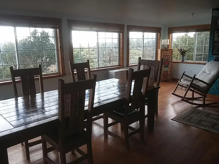 Our 400 sq ft diningroom with hand-built table, Taos furnishings, and seven windows facing amazing sunsets