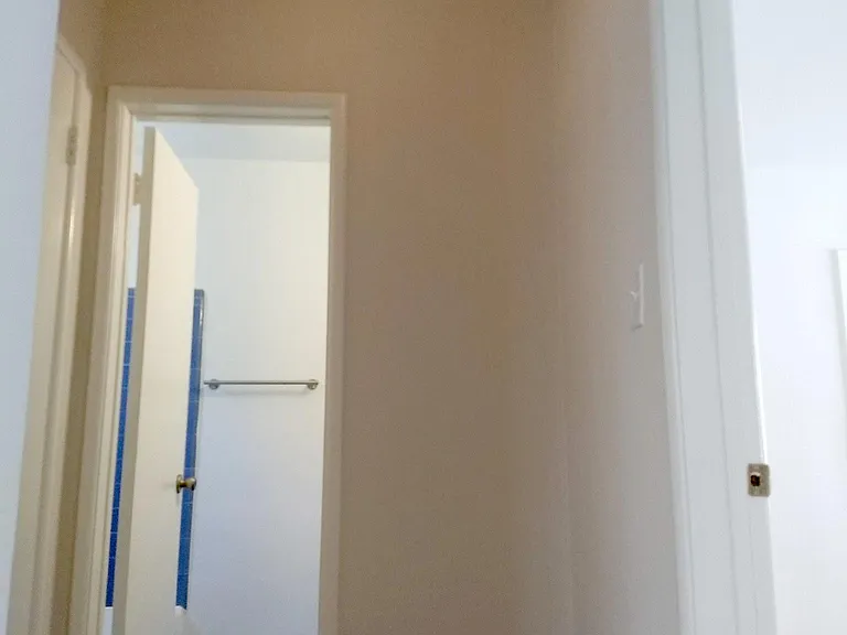 Hallway into the bathroom, bedroom on the right.