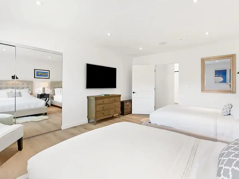 Guest bedroom with large mirrored closets and extra storage space for guests.