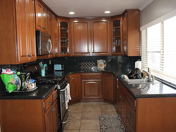 custom cabinets with glass accent doors in corners, bottom corner cabinets have multiple lazy susans for easy access to storage. Built in trash cans in first/left bottom cabinets. Granite counters. Stainless steel stove/built-in microwave/dishwasher incl