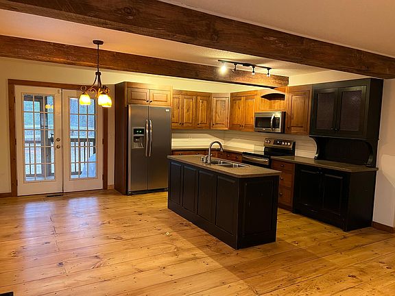 Custom kitchen includes soft close drawers, concealed trashcan pullout, stainless Frigidaire Gallery appliances (fridge with water & ice dispenser, glass top convection range/oven, microwave, and dishwasher), turntable pantry storage, a beautiful attached