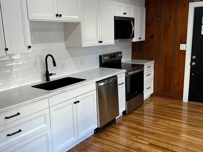 Kitchen with dishwasher, electric range, microwave, and refrigerator with inside water and ice.