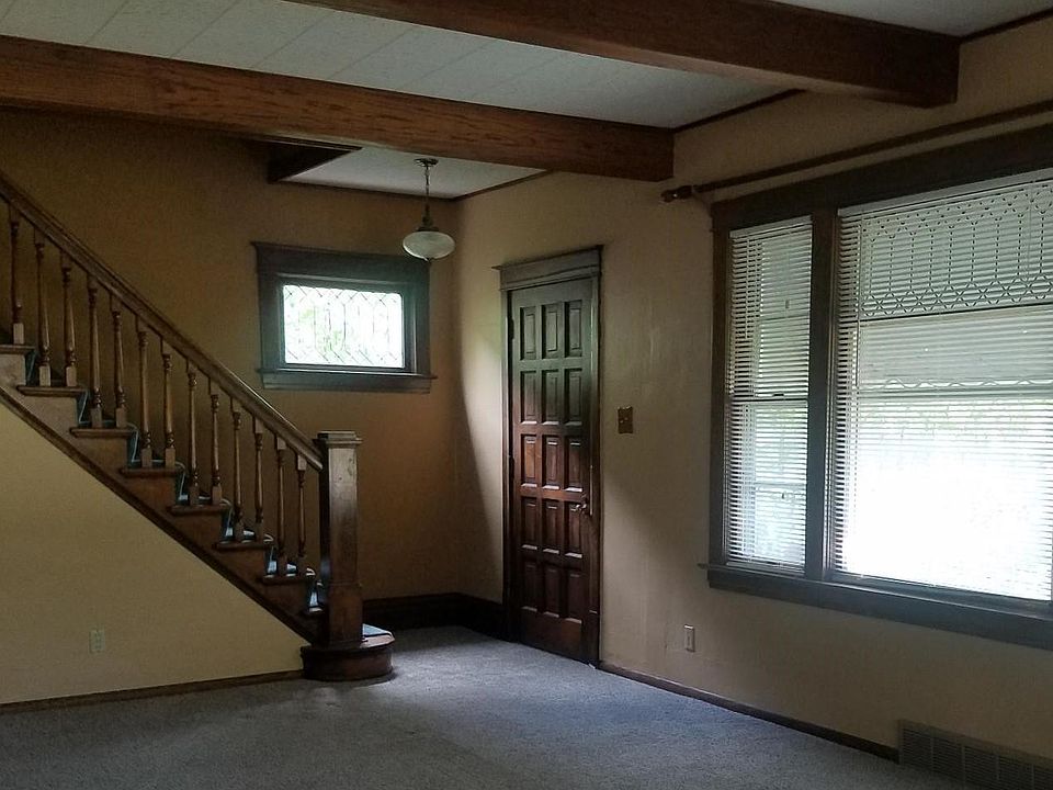 Living Room with beamed ceiling and formal front staircase