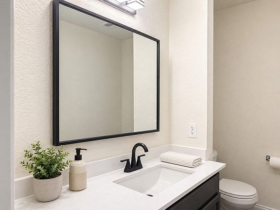Bathroom vanity featuring a rectangular sink, matte black faucet, and white countertop