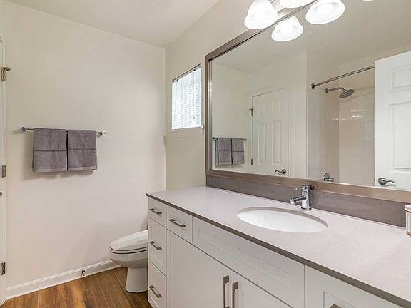 Newly renovated Finish Package III bath with white cabinetry, grey quartz countertop, and hard surface flooring