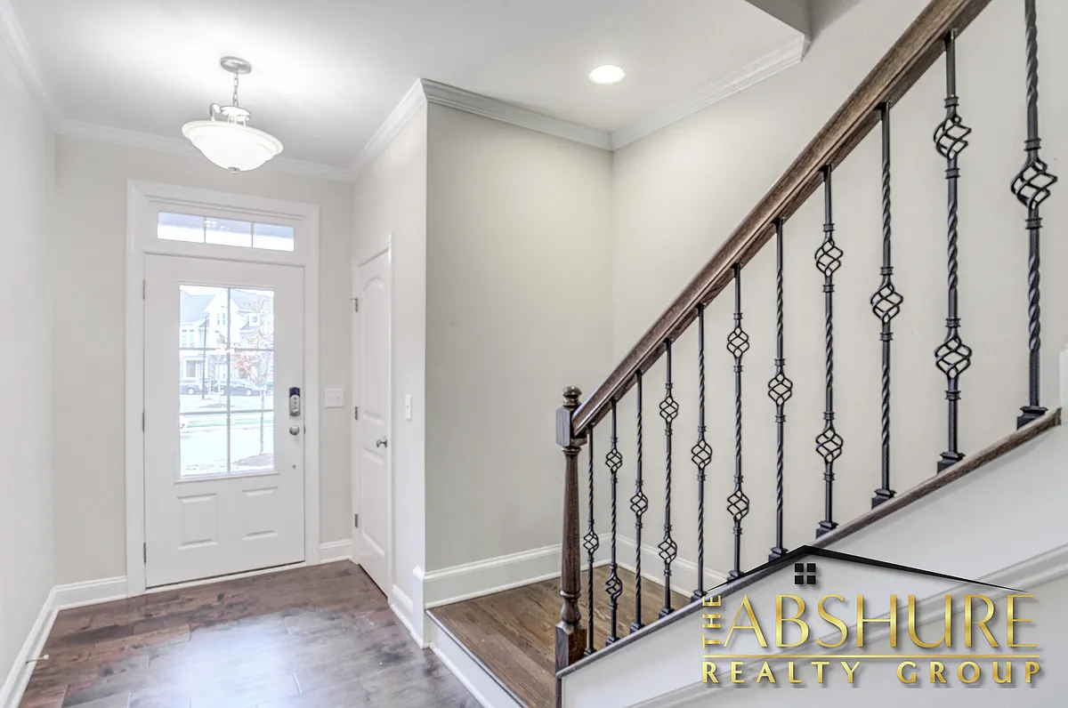 Front entry foyer featuring engineered hardwood flooring, oak tread staircase and wrought iron - 4240 Vallonia Dr