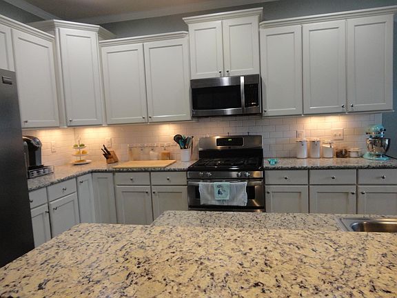 Double oven and gas stove (the top oven is small, it heats up fast and is perfect for every day!) White cabinets with subway tile, light granite with gray sparkle accent-it's gorgeous in person.)