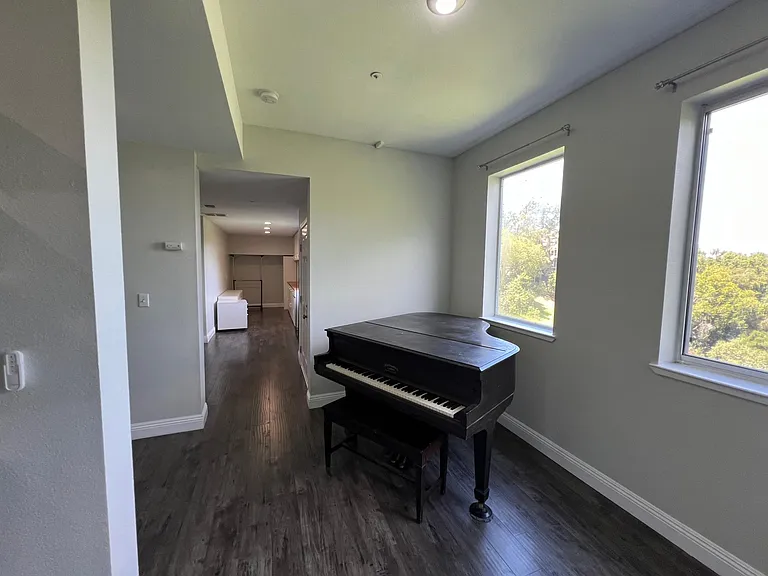 Landing area of the lower level with baby grand piano