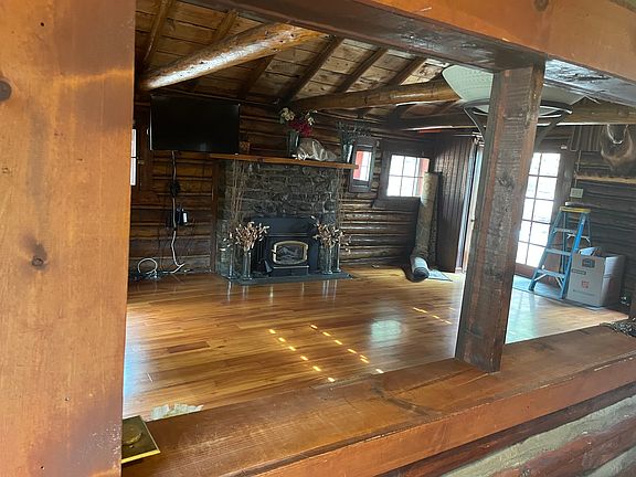 Open great room with beautiful hardwood floors and wood burning stove.