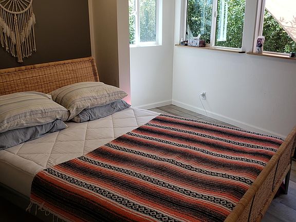 This very light, west facing bed room has a tree house feel to it. Although facing the heat of the day the room stay's cool do to our new 100% UV resistant windows. 4 big windows allow great air flow during the cooler evenings. The bedroom offers great pr