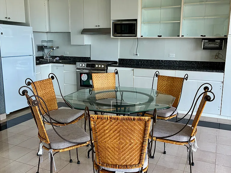 Open-concept kitchen/dining area with refrigerator, stove, microwave, and toaster oven