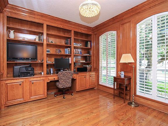 A wall of built-in bookcases surround the desk. Double French doors provide privacy and quiet.