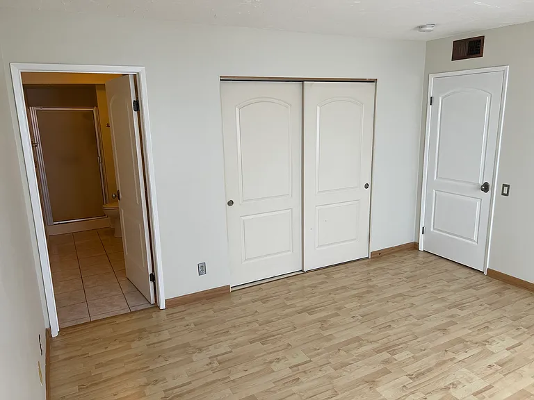 Primary bedroom with closet space and en suite bathroom