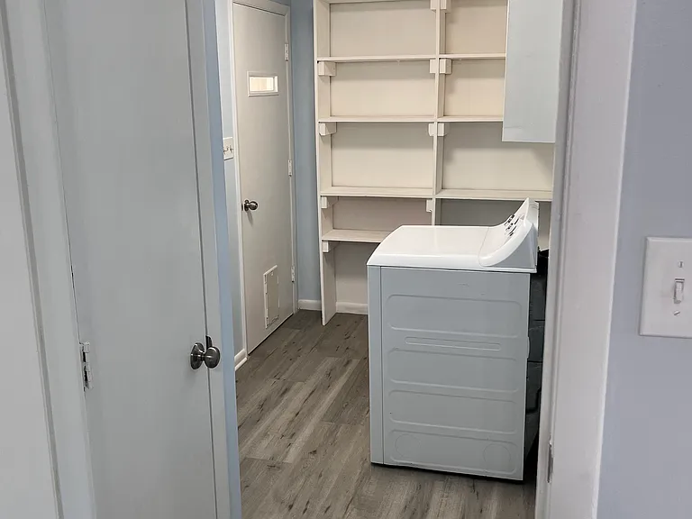 Laundry room with lots of shelves and a pantry.