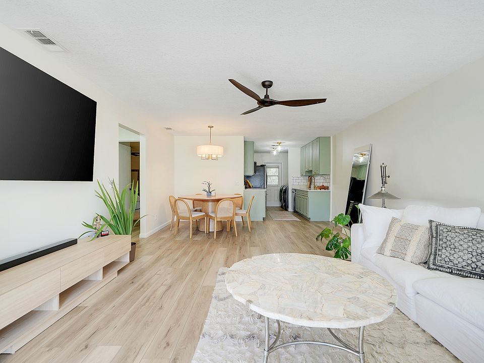 Open layout showcases a cohesive living, dining, and kitchen space with abundant natural flow and functionality.