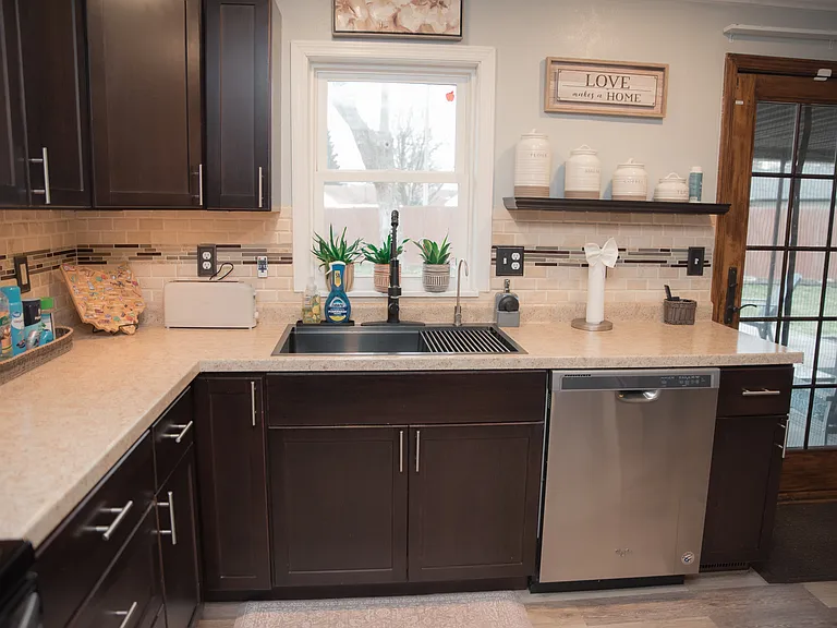 Fully equipped kitchen with modern stainless steel appliances and sleek dark cabinetry.